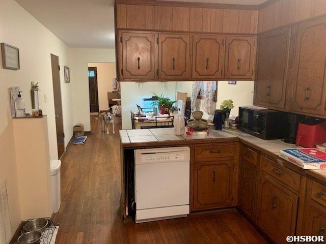 1526 Pearcy Rd, Pearcy, AR 71964 - kitchen featuring dishwasher, black microwave, a peninsula, and dark wood-type flooring