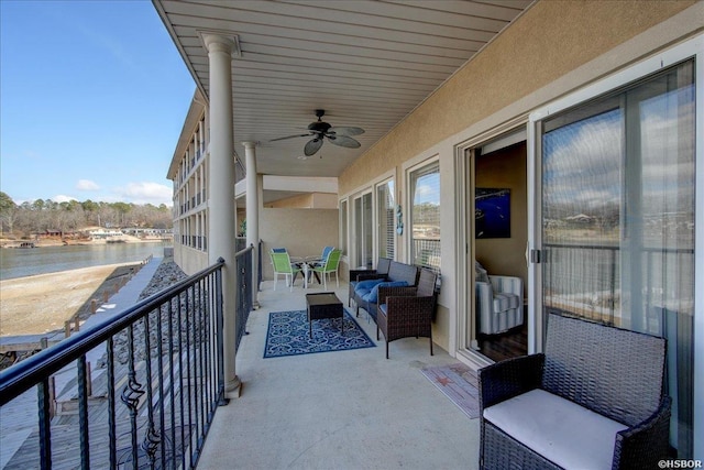 balcony featuring a water view and ceiling fan