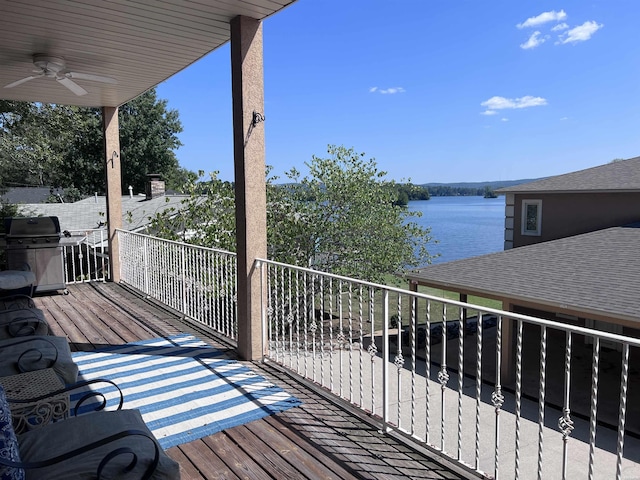 deck with area for grilling, a water view, and a ceiling fan