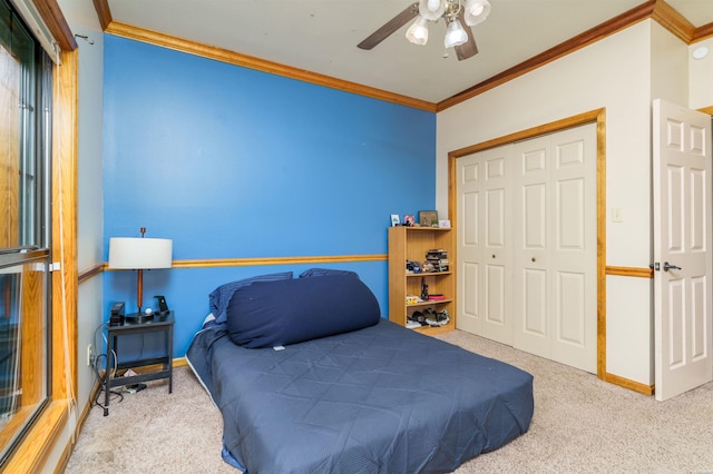carpeted bedroom with a closet, ornamental molding, and baseboards