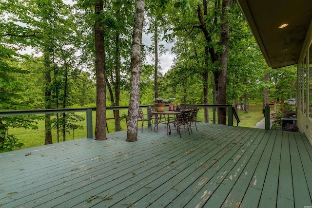 wooden deck with outdoor dining area and cooling unit