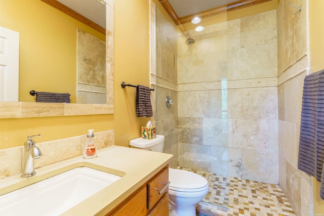 full bathroom featuring crown molding, toilet, tiled shower, and vanity