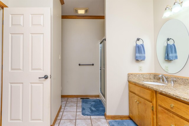 full bathroom featuring visible vents, tile patterned flooring, vanity, baseboards, and a shower with shower door