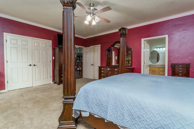 carpeted bedroom featuring crown molding, ceiling fan, two closets, and ensuite bathroom