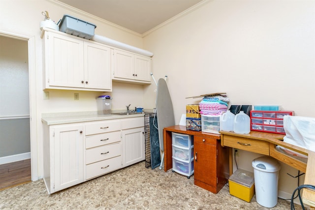 office space featuring baseboards, ornamental molding, and a sink