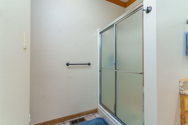 bathroom featuring vanity, baseboards, a shower stall, and visible vents