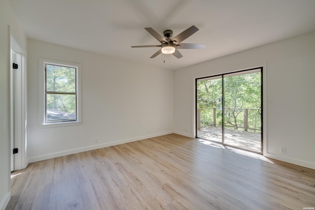 spare room featuring light wood finished floors, ceiling fan, and baseboards