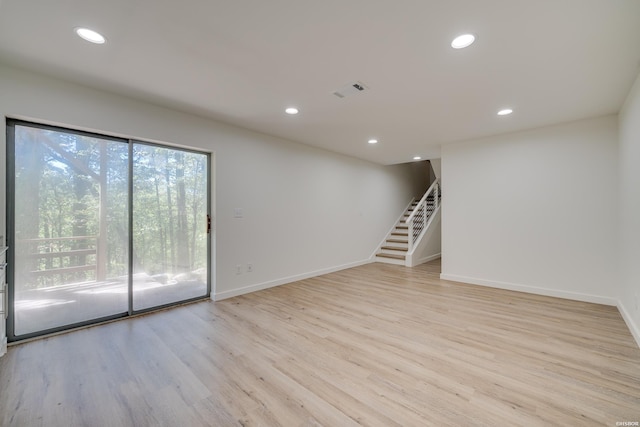 spare room featuring light wood-style floors, recessed lighting, baseboards, and stairs