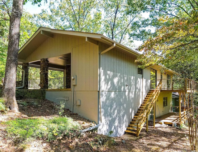 view of side of property featuring crawl space and stairway