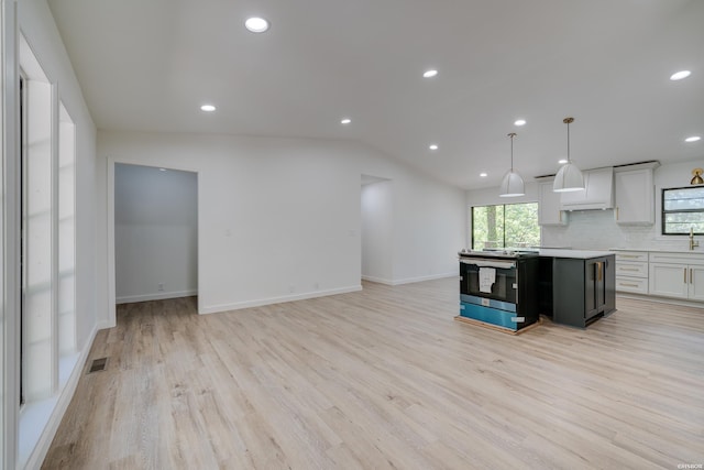 kitchen with open floor plan, decorative light fixtures, stainless steel electric stove, light countertops, and white cabinetry