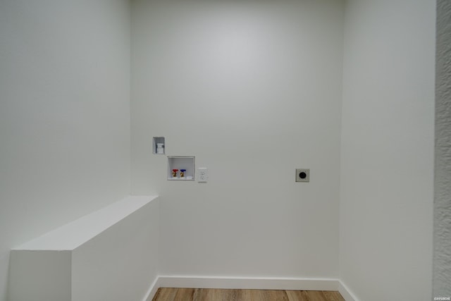 washroom featuring wood finished floors, hookup for a washing machine, electric dryer hookup, and baseboards