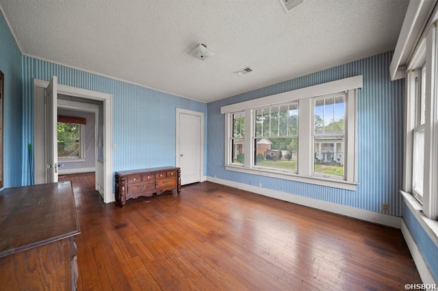 unfurnished room featuring hardwood / wood-style flooring, a textured ceiling, and plenty of natural light