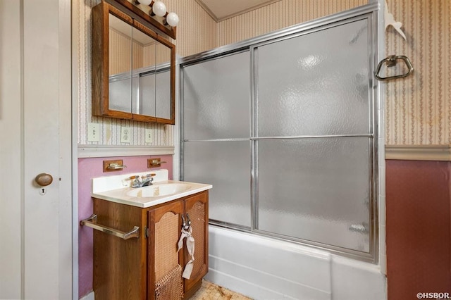 full bath with vanity, wallpapered walls, and bath / shower combo with glass door