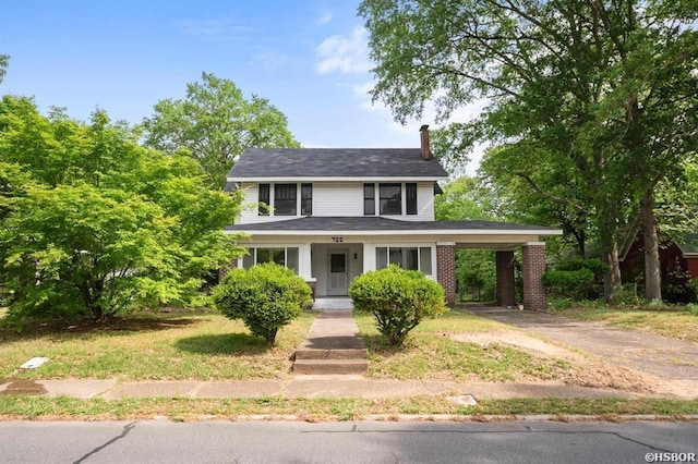 view of front facade with a chimney, aphalt driveway, and an attached carport