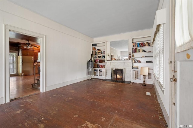 unfurnished living room with hardwood / wood-style flooring, ceiling fan, a fireplace, and plenty of natural light