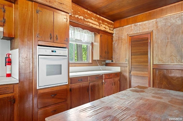 kitchen featuring light countertops, brown cabinetry, and oven