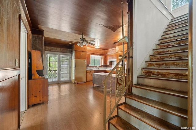 staircase featuring wood finished floors and a ceiling fan