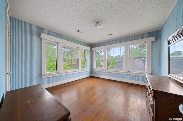 unfurnished sunroom with visible vents and a healthy amount of sunlight