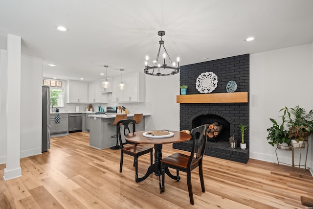 624 Ridgeway St, Hot Springs, AR 71901 - dining room with recessed lighting, light wood-type flooring, a chandelier, and a brick fireplace