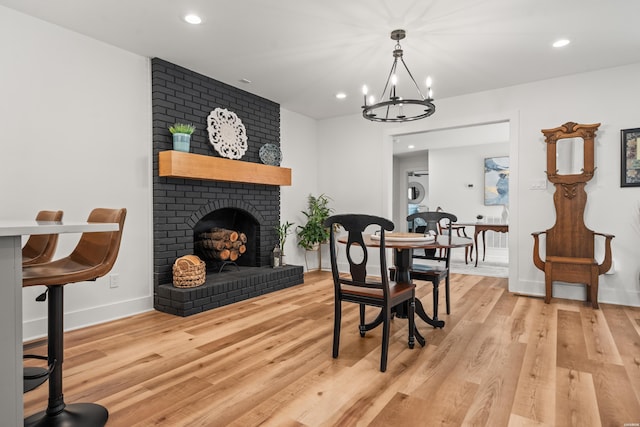 624 Ridgeway St, Hot Springs, AR 71901 - dining room featuring a chandelier, recessed lighting, light wood finished floors, and a brick fireplace