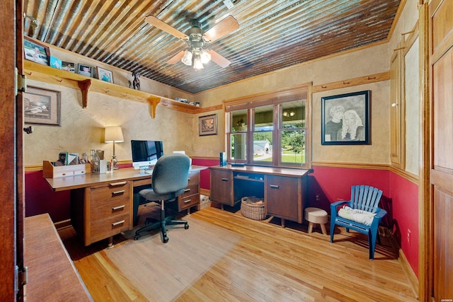 office space with a textured wall, a ceiling fan, and light wood-style floors