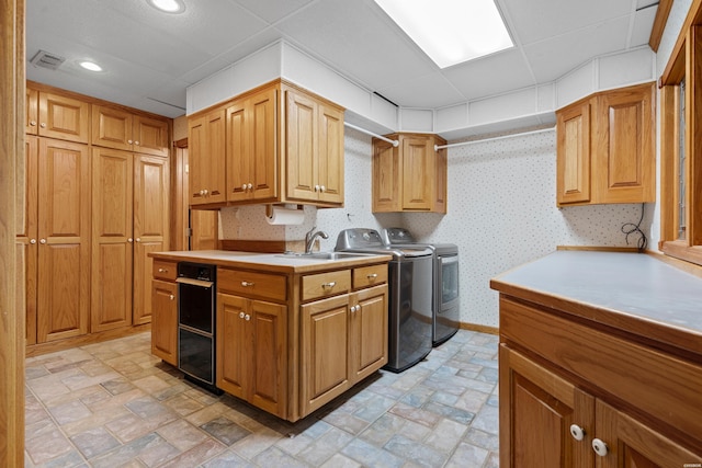 kitchen with light countertops, independent washer and dryer, visible vents, and wallpapered walls
