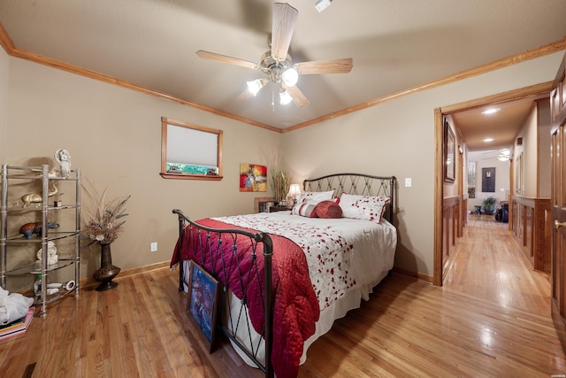 bedroom featuring light wood finished floors, a ceiling fan, baseboards, and crown molding