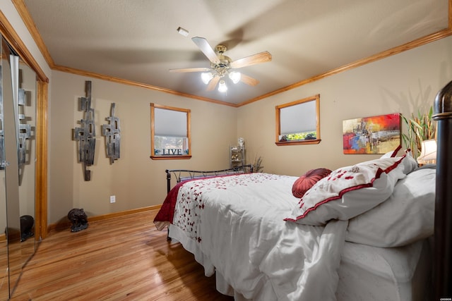 bedroom with a textured ceiling, a ceiling fan, baseboards, light wood-style floors, and crown molding