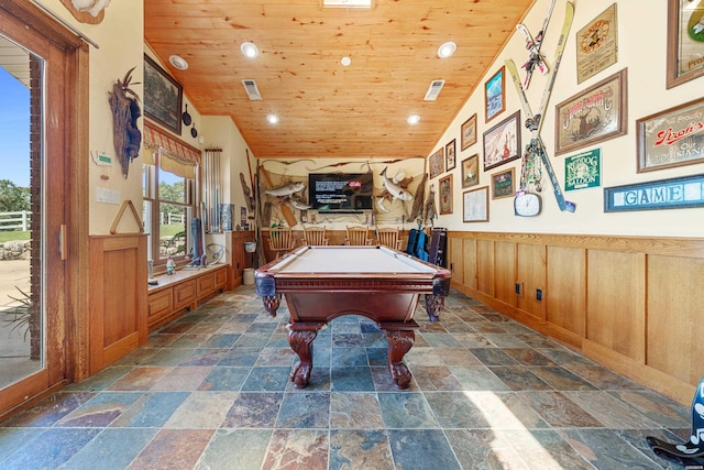 playroom featuring wood ceiling, visible vents, stone tile floors, and wainscoting