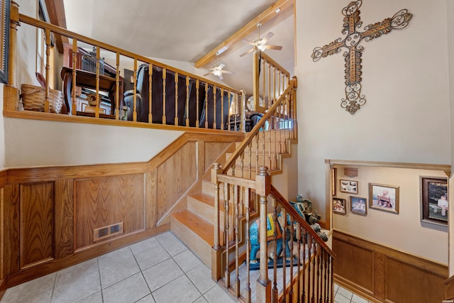 stairs featuring vaulted ceiling with beams, visible vents, wainscoting, ceiling fan, and tile patterned flooring