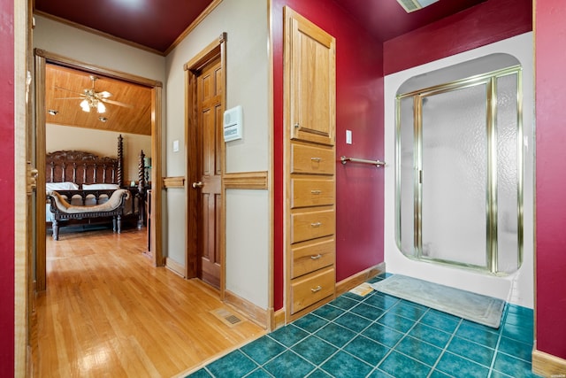 bathroom featuring a stall shower, visible vents, baseboards, and wood finished floors