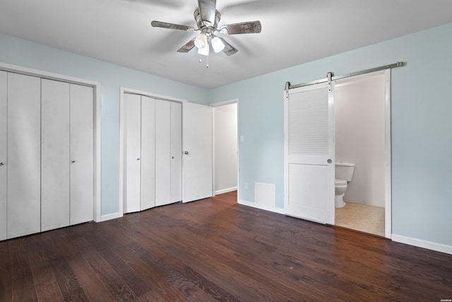75 Grant 7, Sheridan, AR 72150 - unfurnished bedroom featuring a barn door, multiple closets, baseboards, wood finished floors, and ensuite bathroom