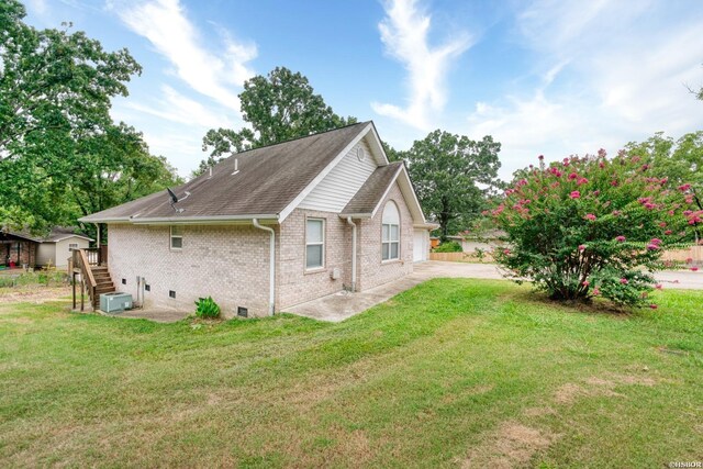 view of home's exterior featuring a shingled roof, crawl space, brick siding, and a yard