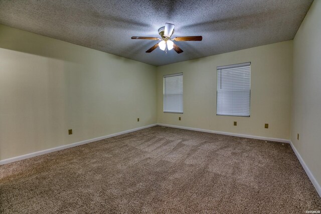 carpeted spare room with ceiling fan, a textured ceiling, and baseboards