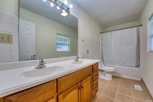 full bathroom featuring toilet, tile patterned flooring, visible vents, and a sink