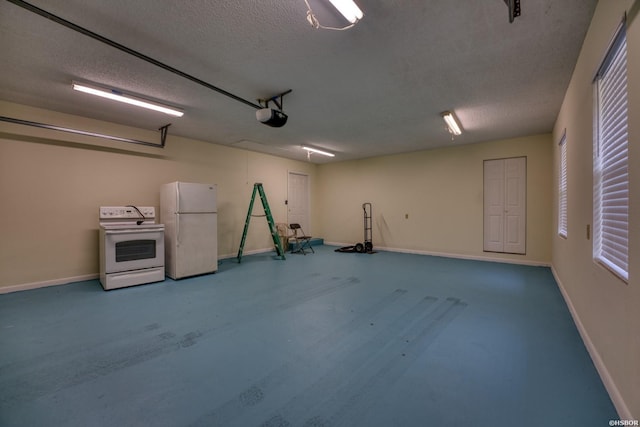 garage featuring baseboards, a garage door opener, and freestanding refrigerator