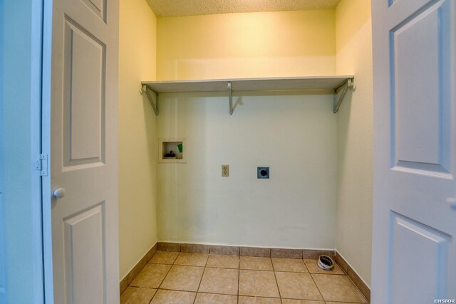 washroom featuring laundry area, baseboards, hookup for a washing machine, electric dryer hookup, and light tile patterned flooring