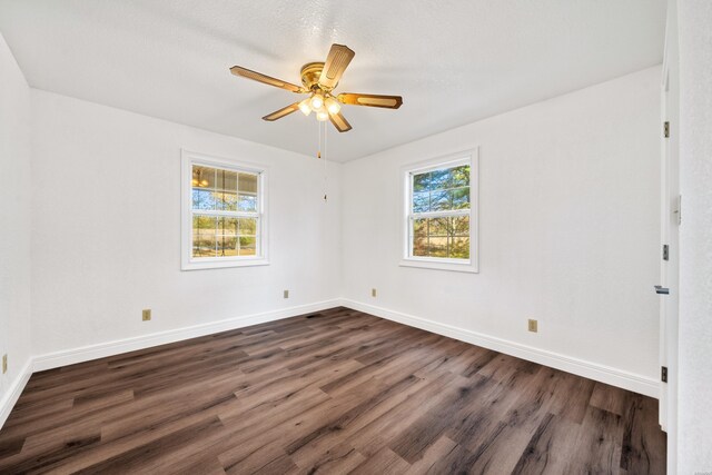 spare room featuring baseboards, dark wood finished floors, and a ceiling fan