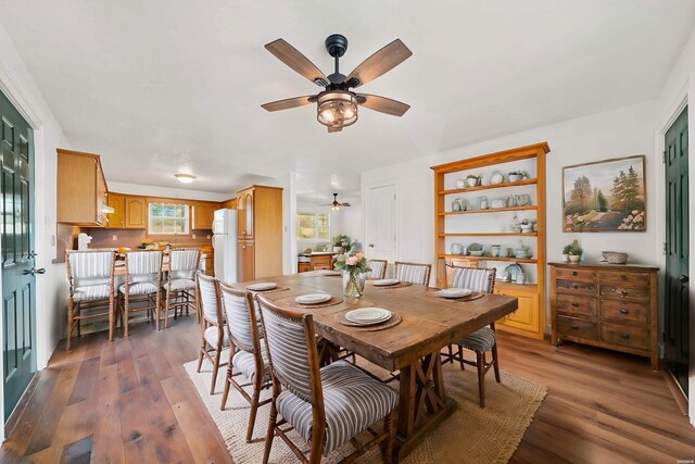 dining area with dark wood-type flooring, visible vents, and a ceiling fan