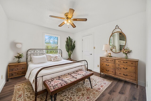 bedroom featuring dark wood-style floors, baseboards, and a ceiling fan