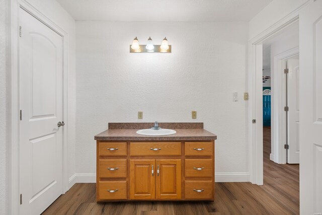 bathroom featuring wood finished floors, vanity, and baseboards