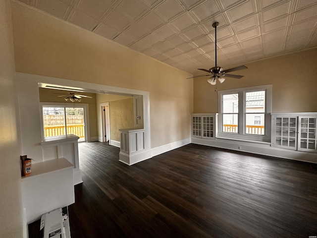 interior space featuring an ornate ceiling, a healthy amount of sunlight, baseboards, and dark wood-style floors