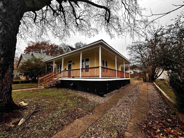 view of front of house featuring covered porch and dirt driveway