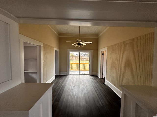 interior space with dark wood-style floors, baseboards, a ceiling fan, and crown molding