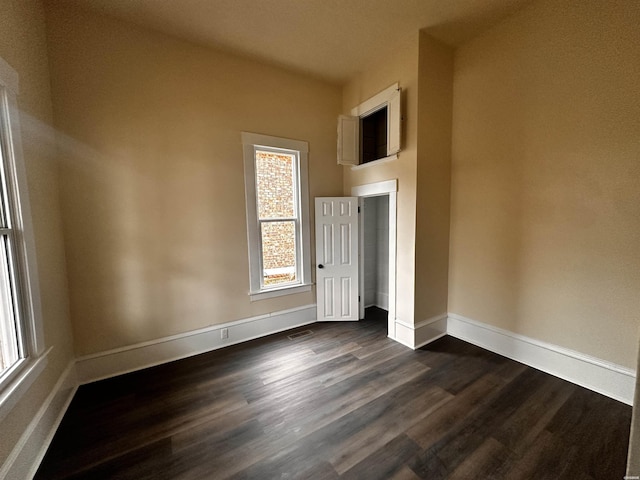 unfurnished bedroom with visible vents, baseboards, and dark wood-style flooring