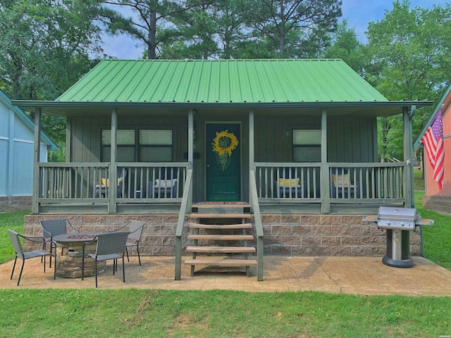 150 Shady Oak Trl, Hot Springs, AR 71913 - view of front of property featuring covered porch, a fire pit, board and batten siding, and a metal roof
