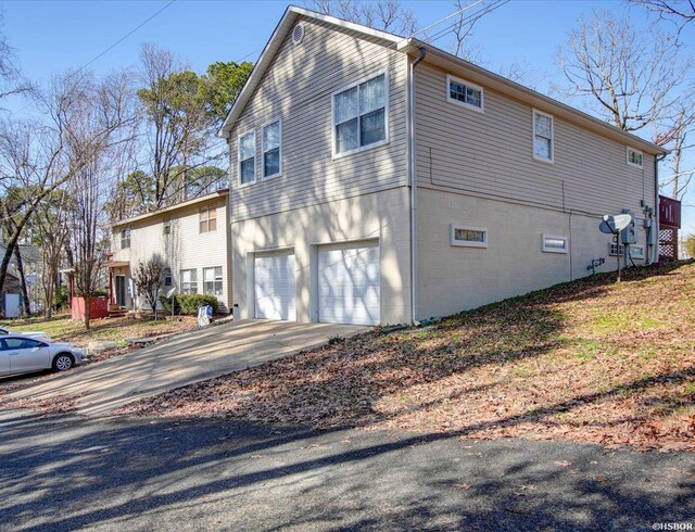 view of property exterior with a garage and concrete driveway