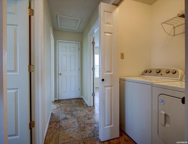 washroom featuring laundry area, attic access, baseboards, and washing machine and clothes dryer