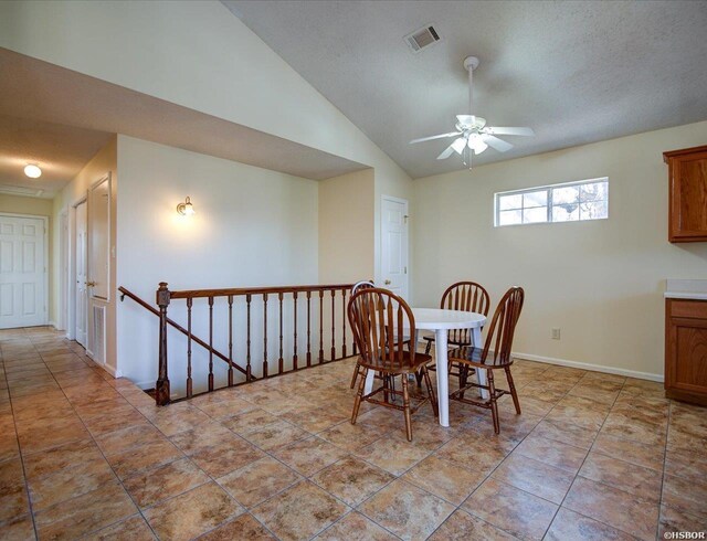 dining area featuring visible vents, a ceiling fan, vaulted ceiling, a textured ceiling, and light tile patterned flooring