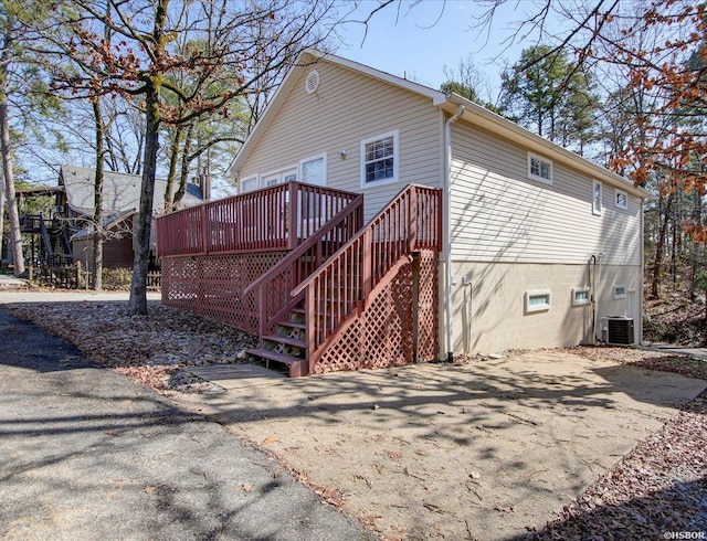 back of property with a deck, central AC, and stairway